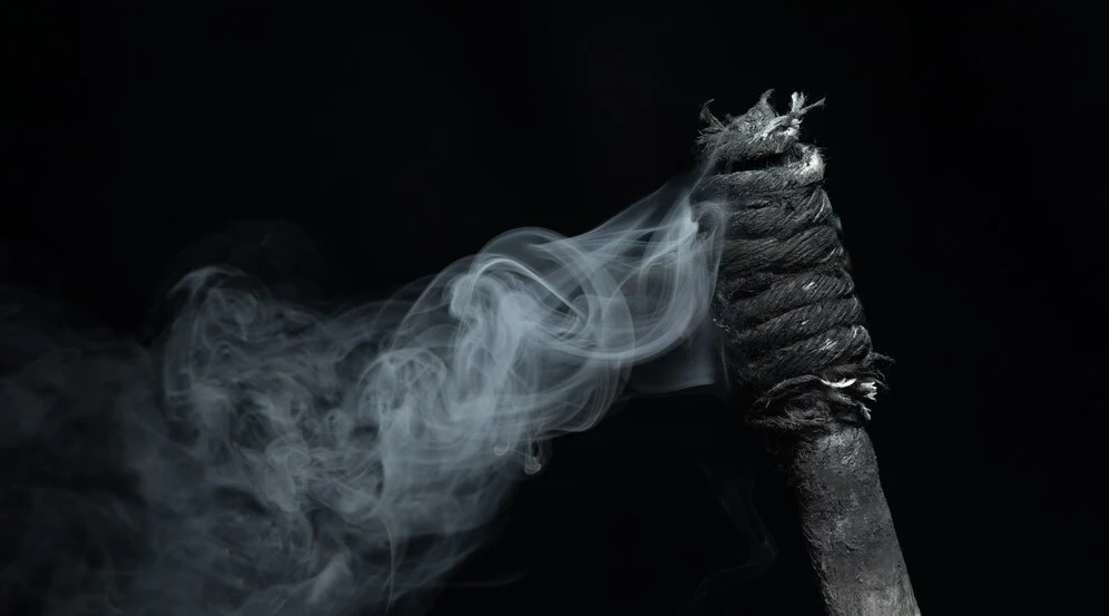 a smoldering torch which has burnt out.